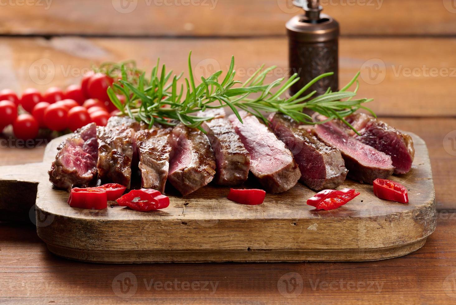 https://static.vecteezy.com/system/resources/previews/019/621/854/non_2x/roasted-piece-of-beef-ribeye-cut-into-pieces-on-a-vintage-brown-chopping-board-well-done-appetizing-steak-photo.jpg