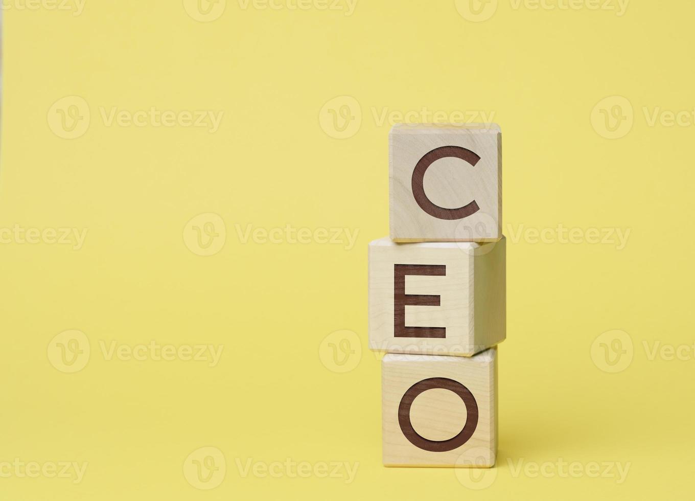 CEO inscription on wooden cubes, yellow background photo