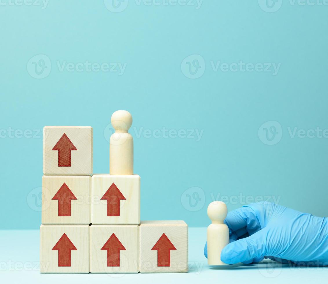 wooden figures of men on a ladder made of blocks. The concept of career advancement, starting at work photo