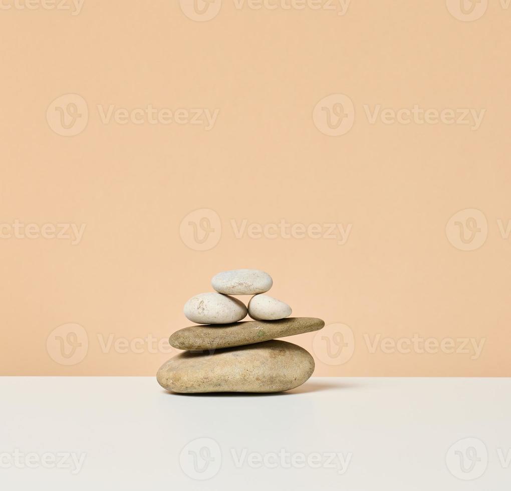 stack of round stones on a beige background. Scene for demonstration of cosmetic products, advertising photo