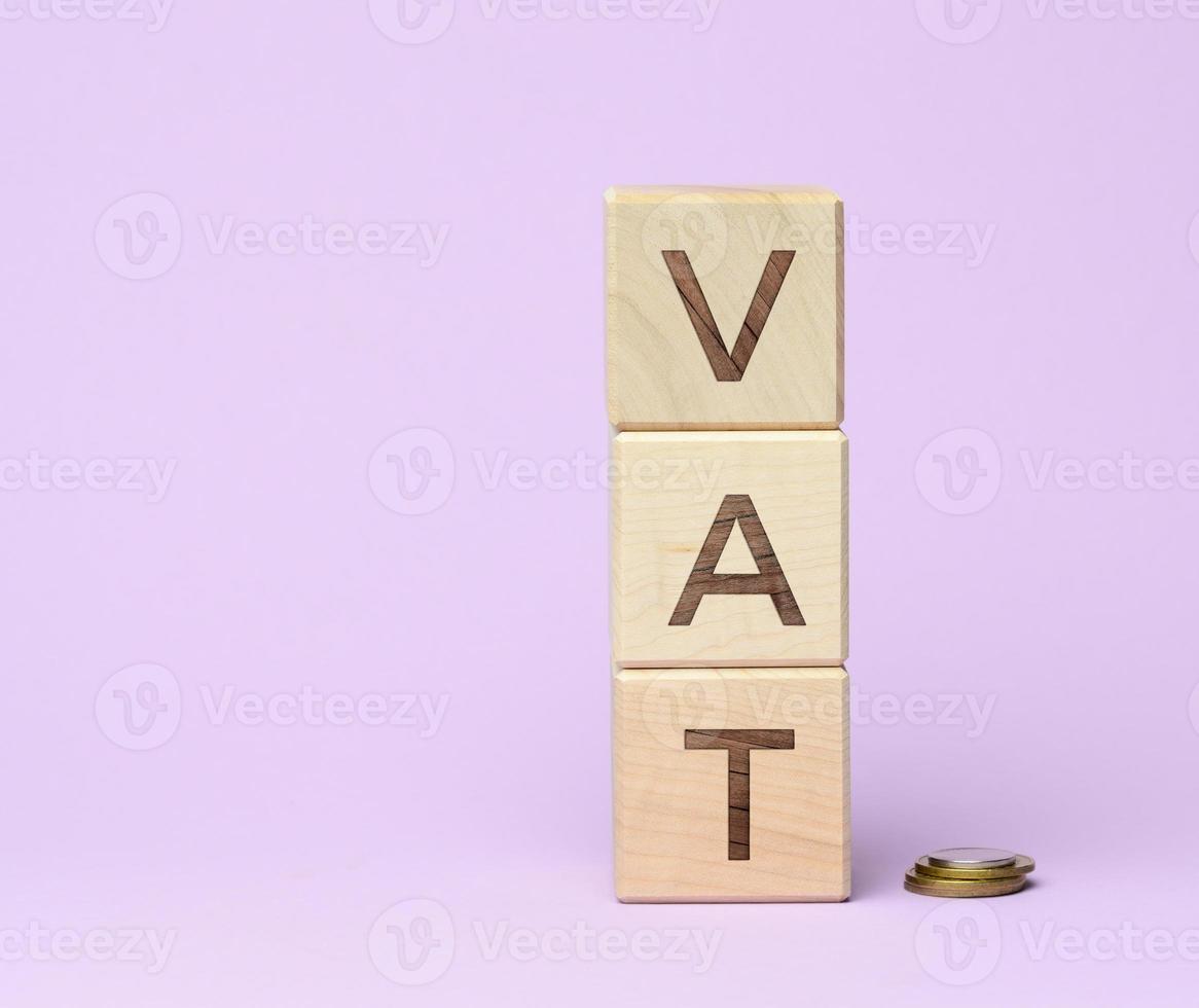 wooden blocks with the inscription BAT and metal coins on a purple background. Product Tax Refund Concept photo