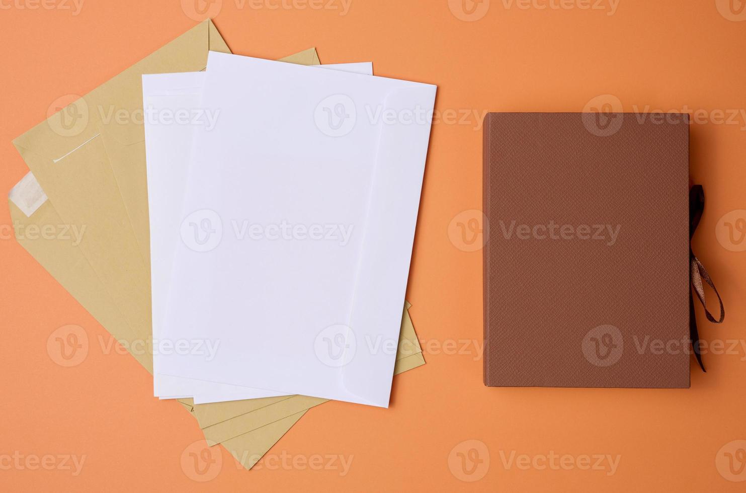 stack of white envelopes on orange background, top view photo
