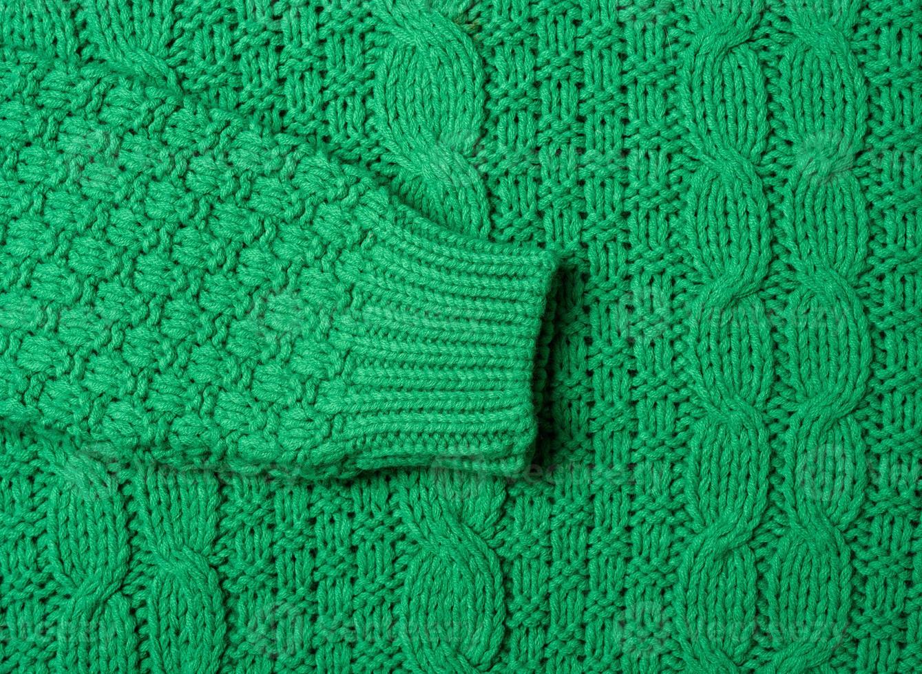 chunky knit of a sweater with green threads, full frame. Cozy and warm clothes photo