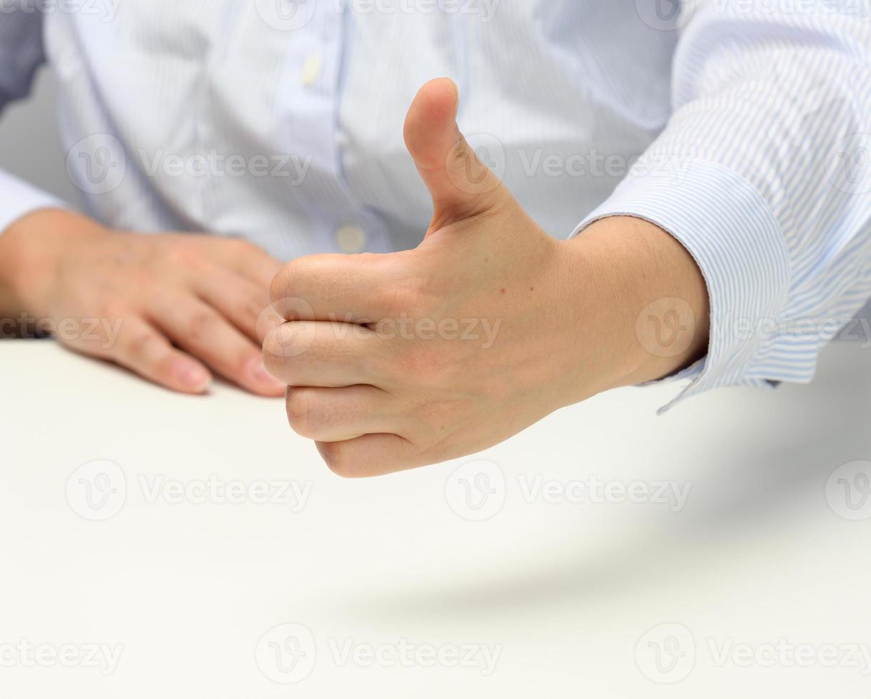 woman in blue striped shirt showing like gesture with left hand, approval and recommendation photo