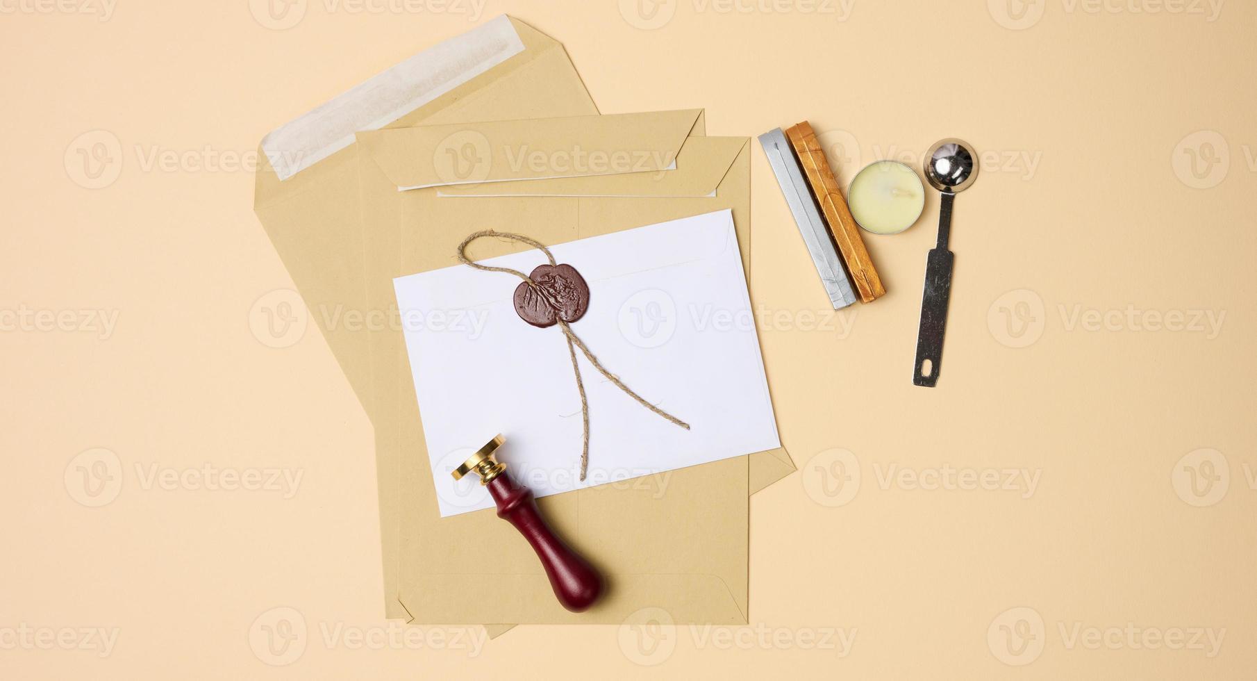 sealed white envelope with brown wax seal on beige background photo