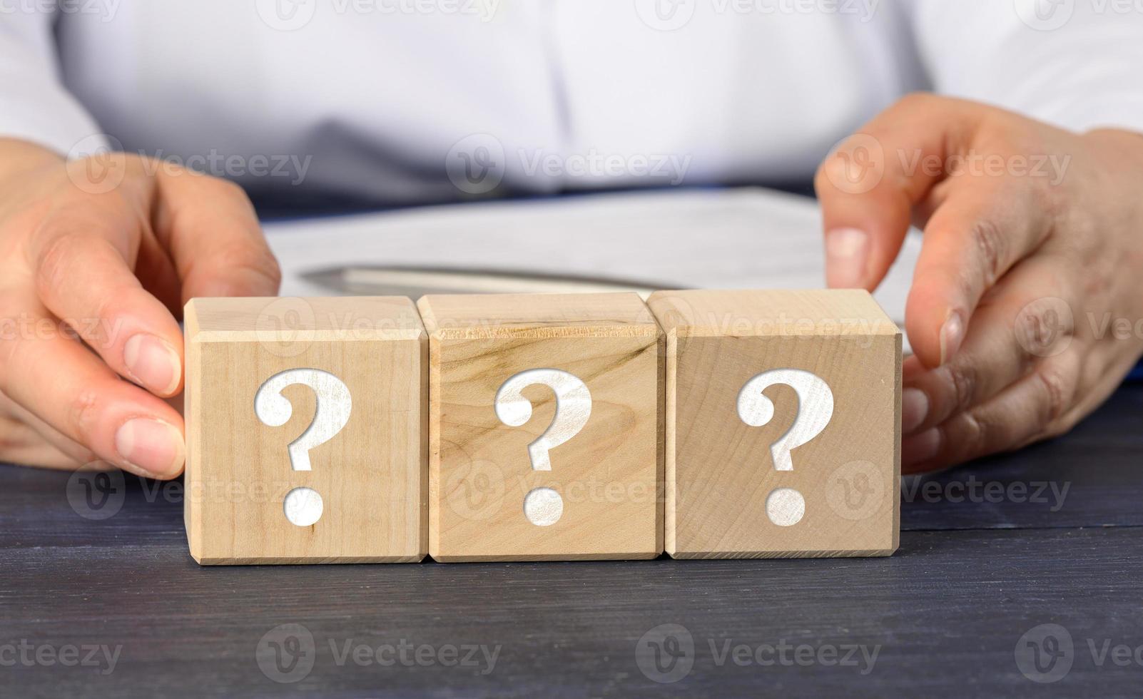 woman holding wooden cubes with question marks. photo