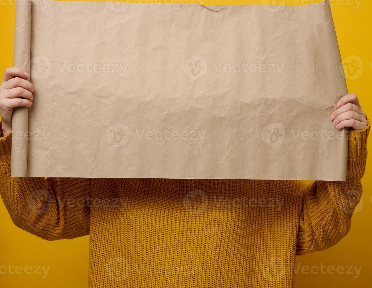 woman holding blank brown parcel of brown kraft paper. Place for an inscription, advertisement, information photo