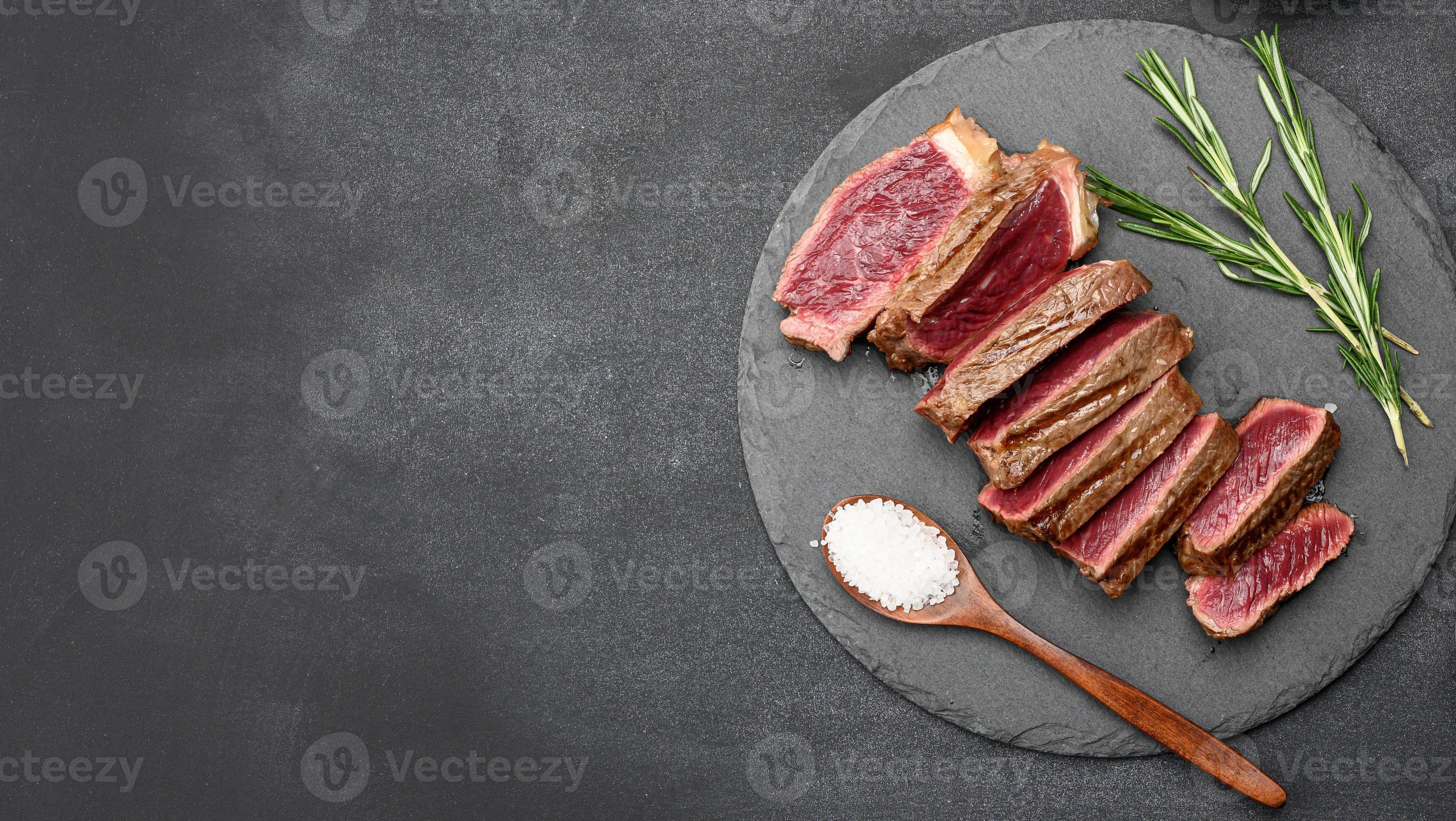 fried beef steaks cut into pieces on a black board, the degree of