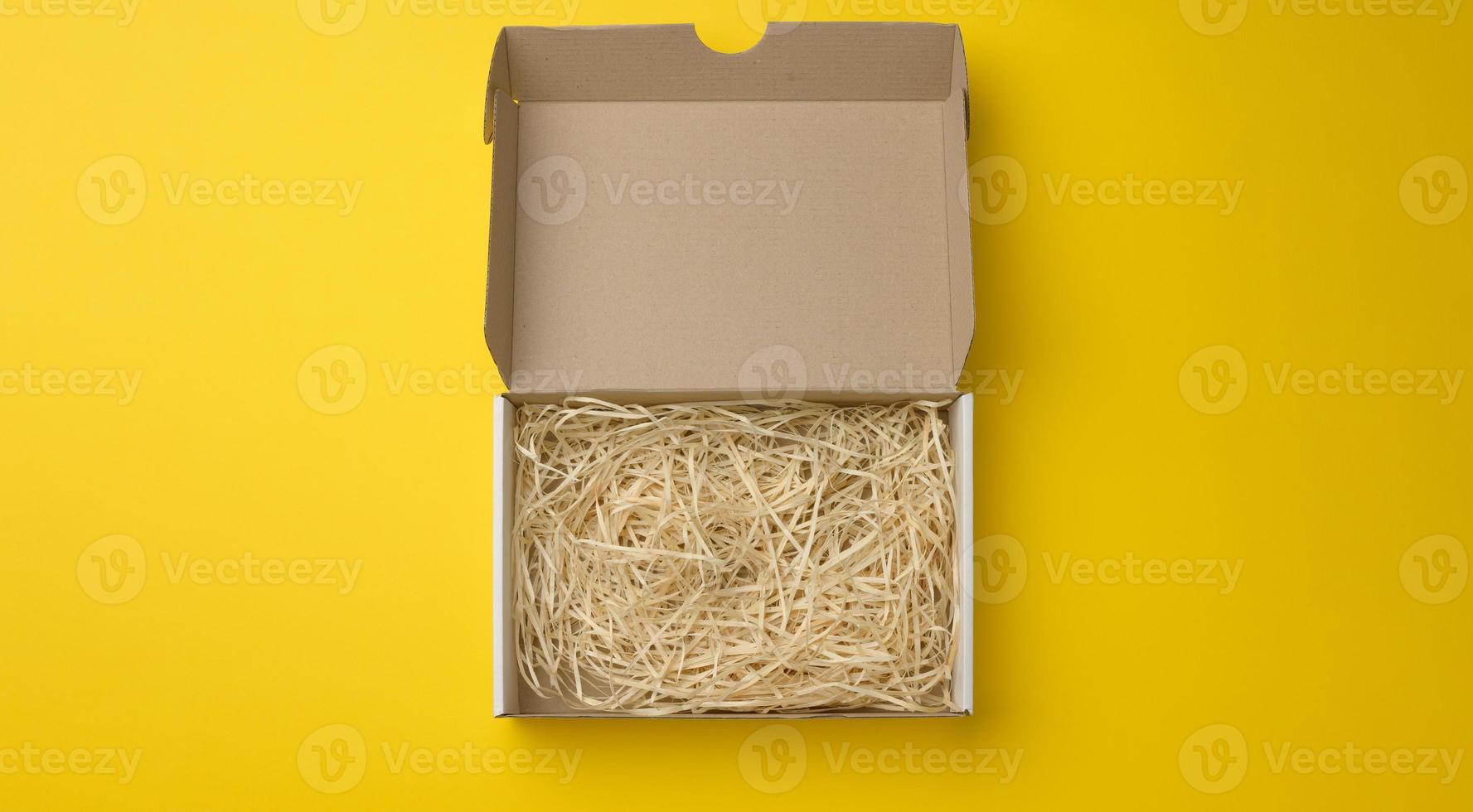 rectangular open corrugated paper box with sawdust inside photo