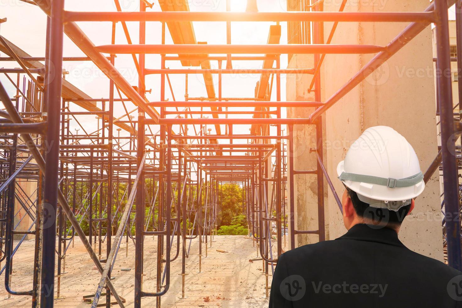 architect-engineer check work construction in a building site with sunset light morning photo