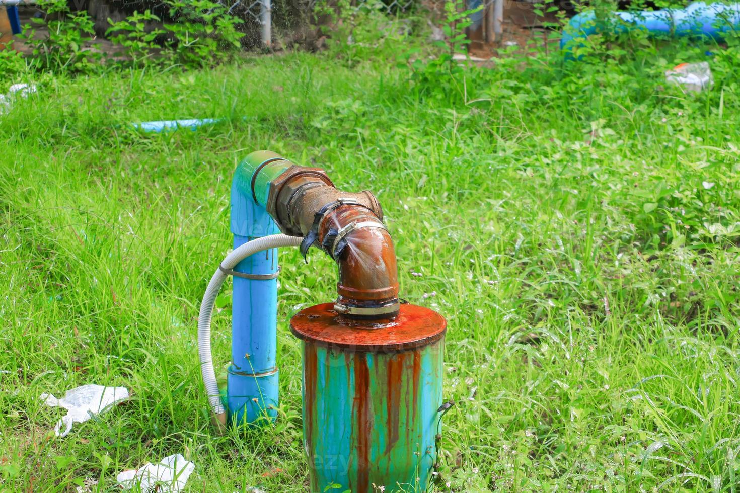 plumbing main tube and water leak,  old tap pipe steel rust  on grass floor photo