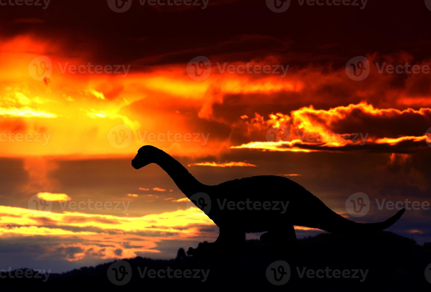 silhouettes of dinosaurs in the forest on sunset background with copy space add text photo