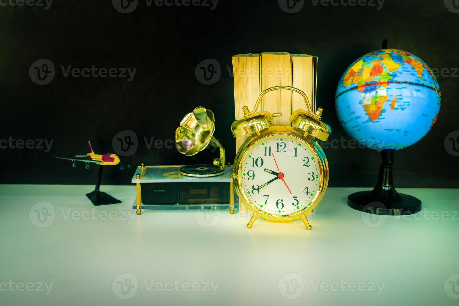 alarm clock old vintage gold and globe plastic - book,   gramophone over white on black background. with copy space add text. color cinematic Vintage style tone photo