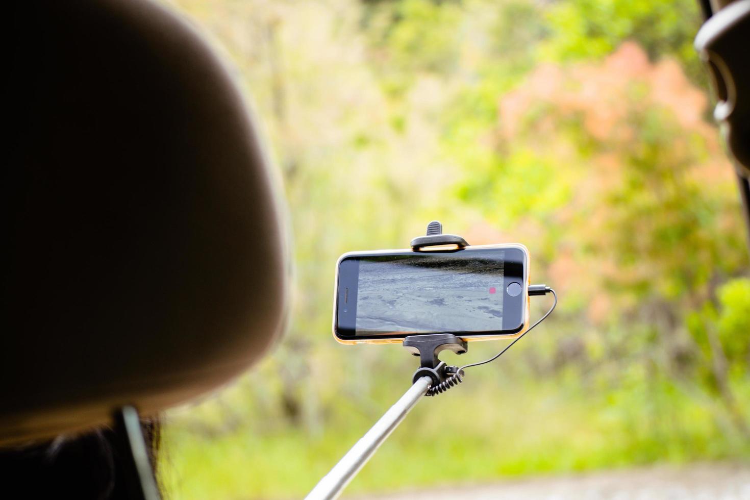 Tourist taking panoramic picture record video of summer nature landscape on road trip outdoors in summer. Travel and adventure. Traveler takes video of landscape on smartphone photo