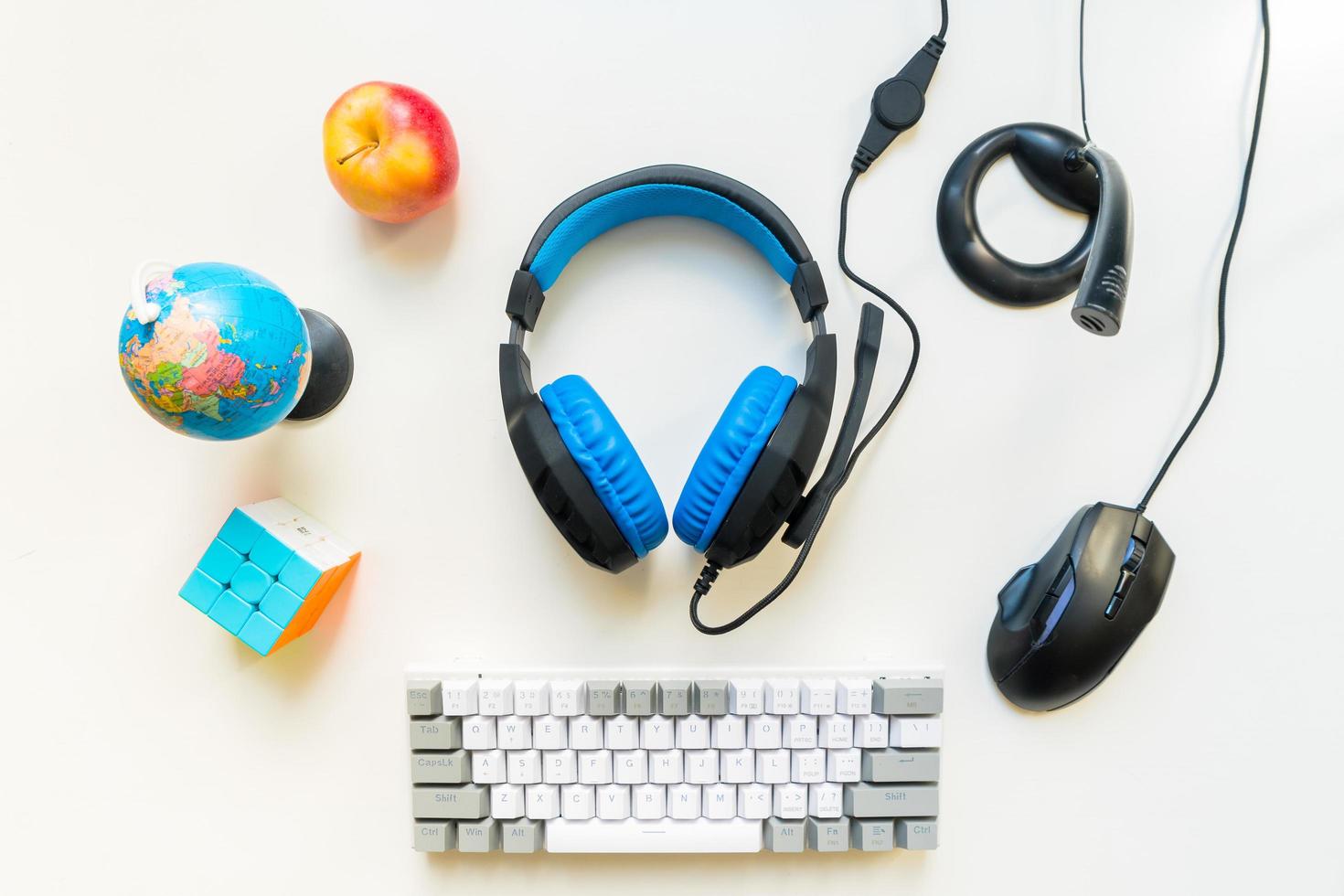 Above top view student gamer workspace concept, gaming gear, mouse, keyboard, joystick, headset on white background with copy space and nutrition for kid. Elementary set up photo