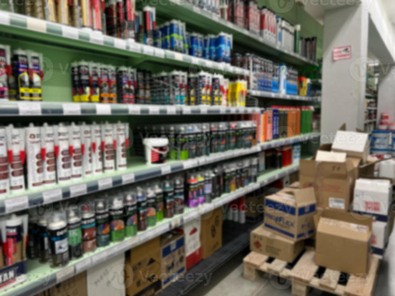 A blurry image of a hardware store with paints, varnish, brushes in a building materials store as a trading background. For the photo