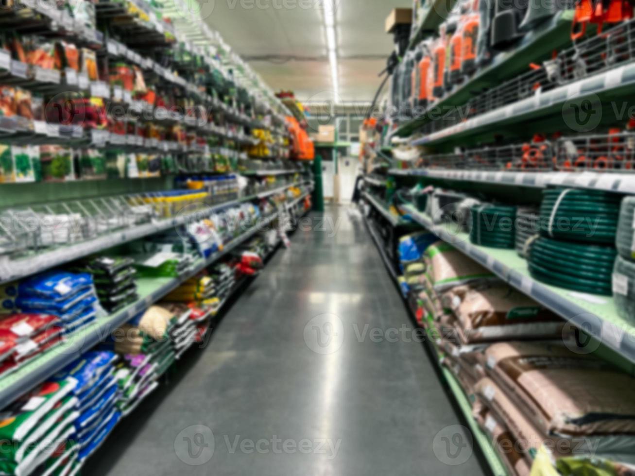 A blurry image of a hardware store with paints, varnish, brushes in a