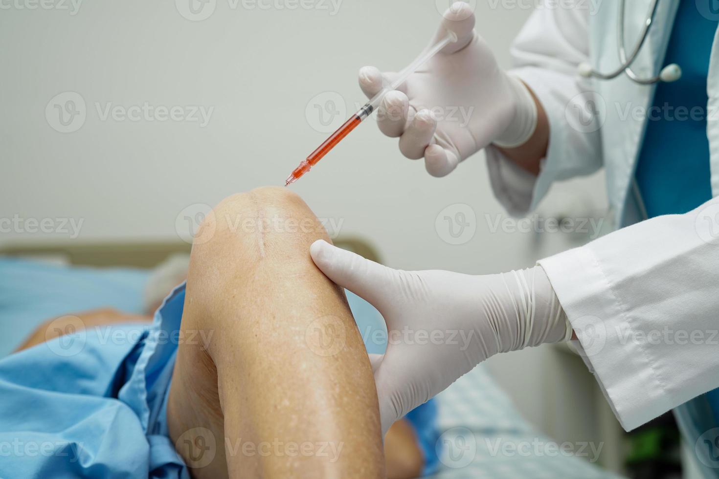 Asian doctor inject Hyaluronic acid platelet rich plasma into the knee of senior woman to walk without pain. photo