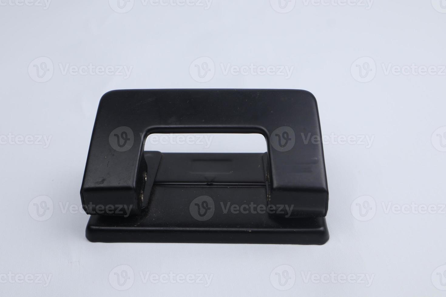 Office paper perforator isolated on white background. Office tool that is used to create holes in sheets of paper. Paper Metal Stationary Hole Puncher. Office file-punch photo