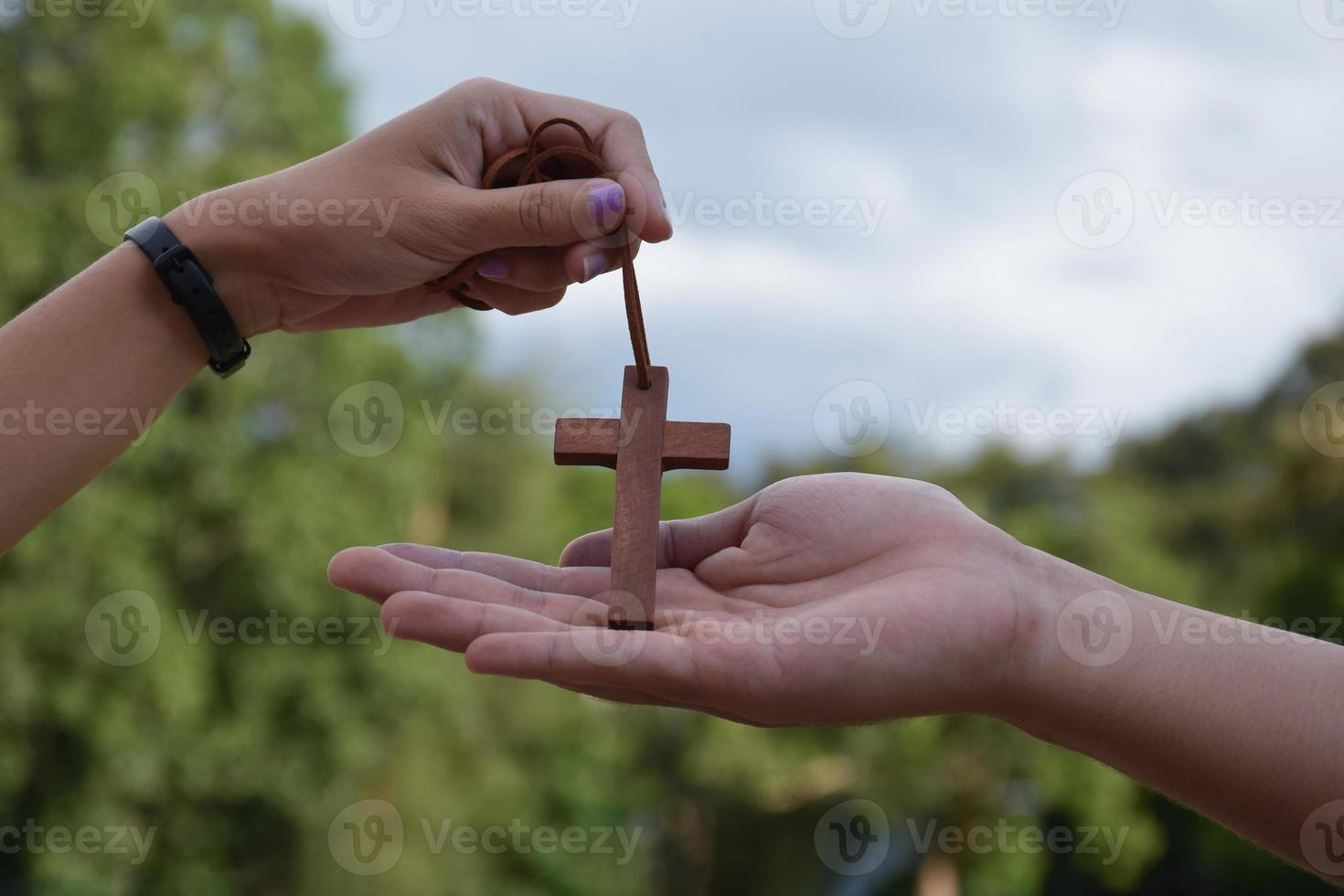 Asian young Christian people show and giving necklace with a cross to other people, soft and selective focus, concept for showing pride in being a Christian to other people around the world. photo