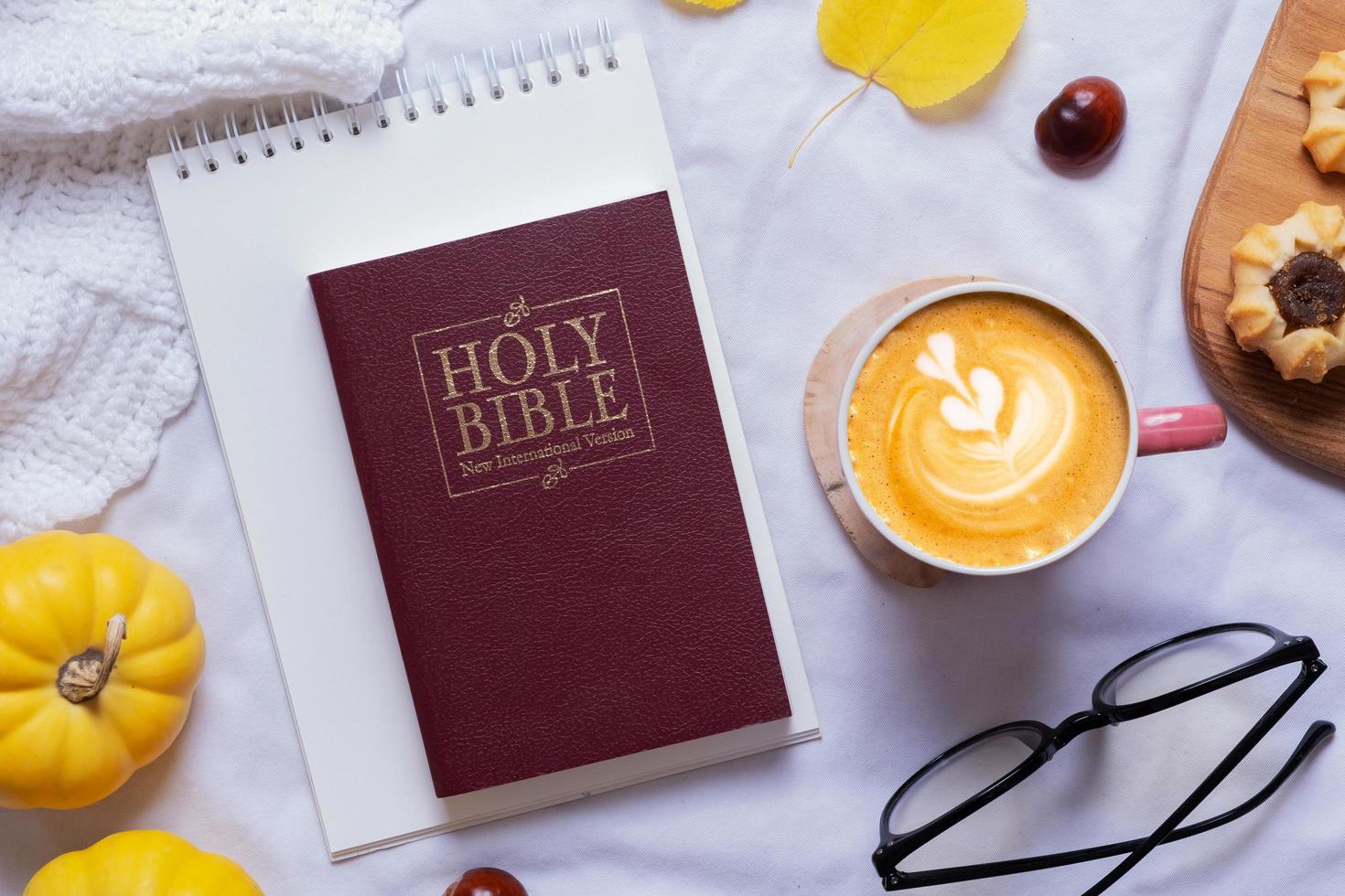 Holy Bible and latte with autumn cozy decor top view. Bible study fall concept photo