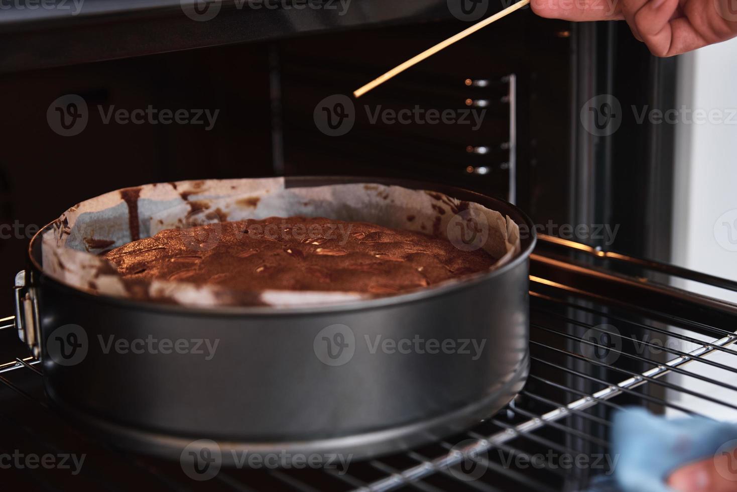 Housewife prepare cake in kitchen. Homemade cake baking in oven photo