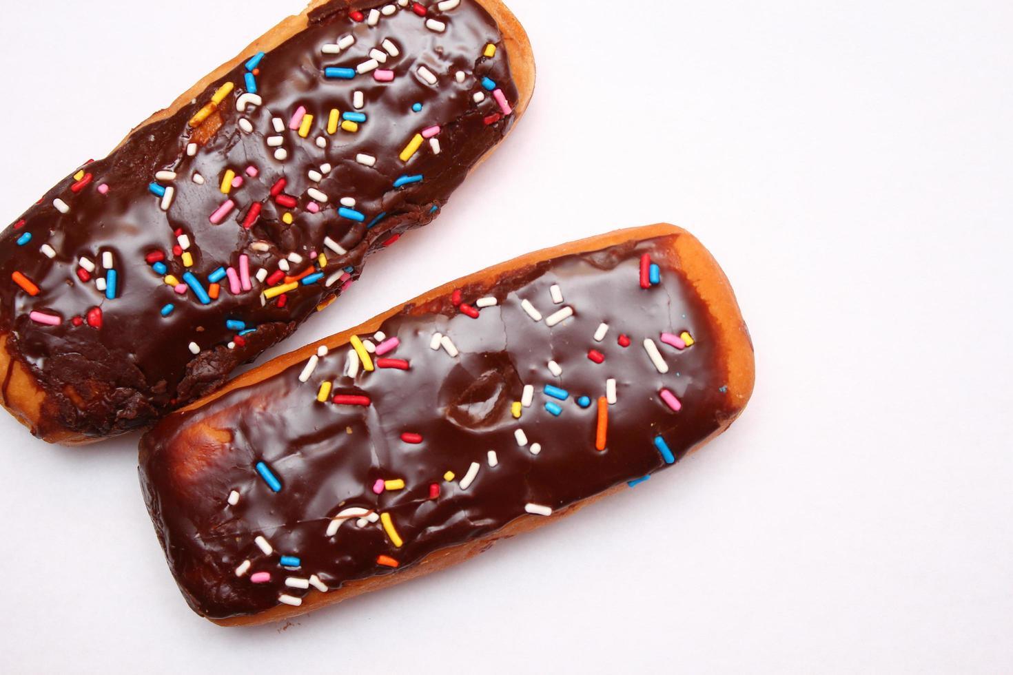 Chocolate donut bar topped with multicolored sugar flakes. laid on a white background photo