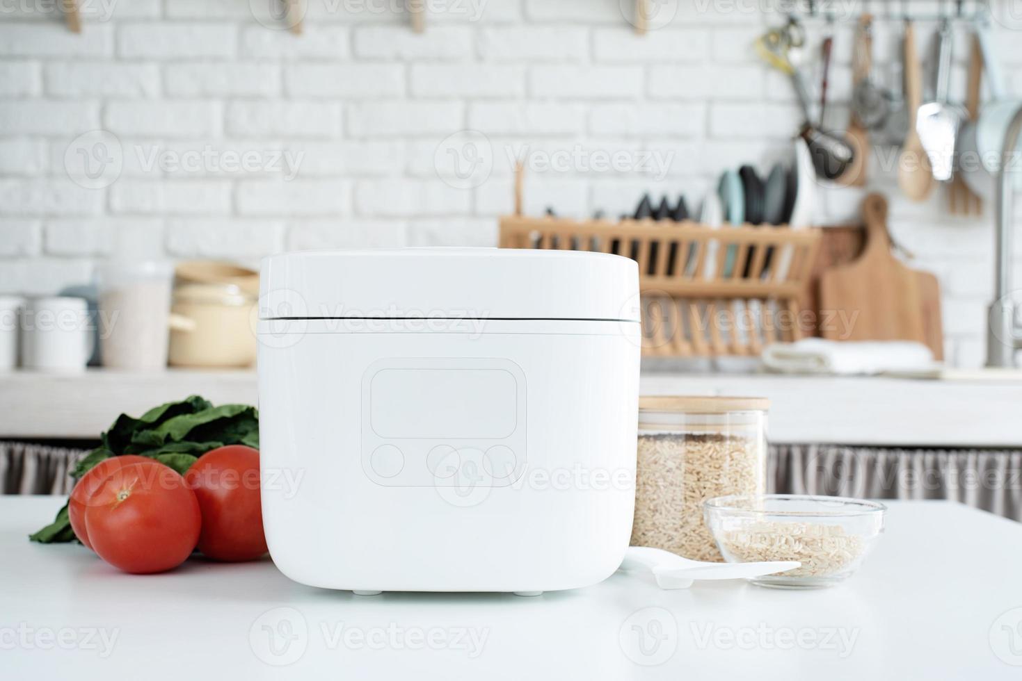 Electric rice cooker on wooden counter-top in the kitchen photo