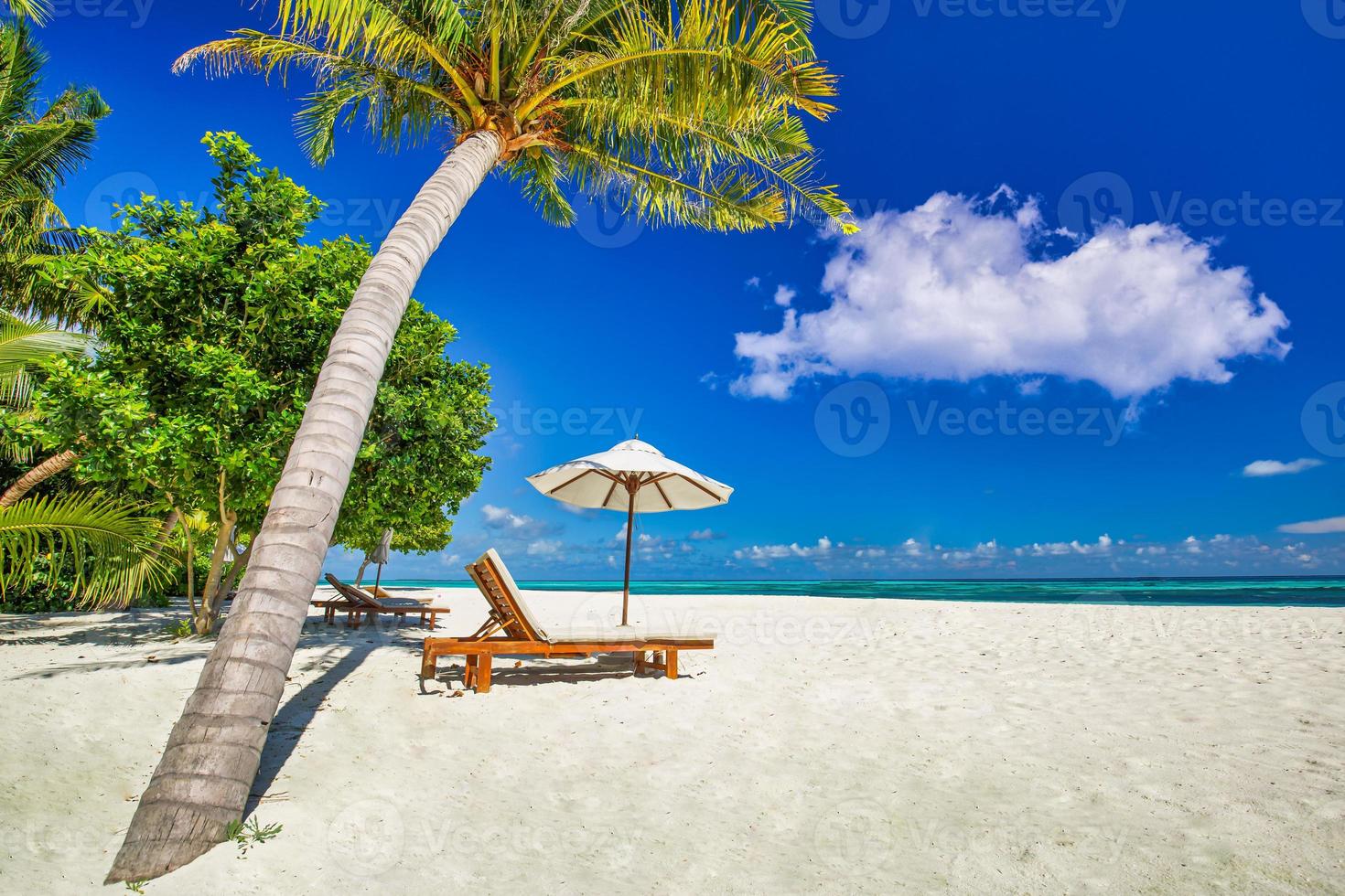 increíble playa de vacaciones. sillas en la playa de arena cerca del mar. turismo de vacaciones románticas de verano. hermoso paisaje de isla tropical. paisaje costero tranquilo, horizonte costero de arena relajante, hojas de palma foto