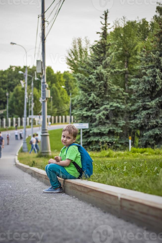 Portrait of a child, a boy against the backdrop of urban landscapes of skyscrapers and high-rise buildings in the open air. Children, Travel. Lifestyle in the city. Center, streets. photo