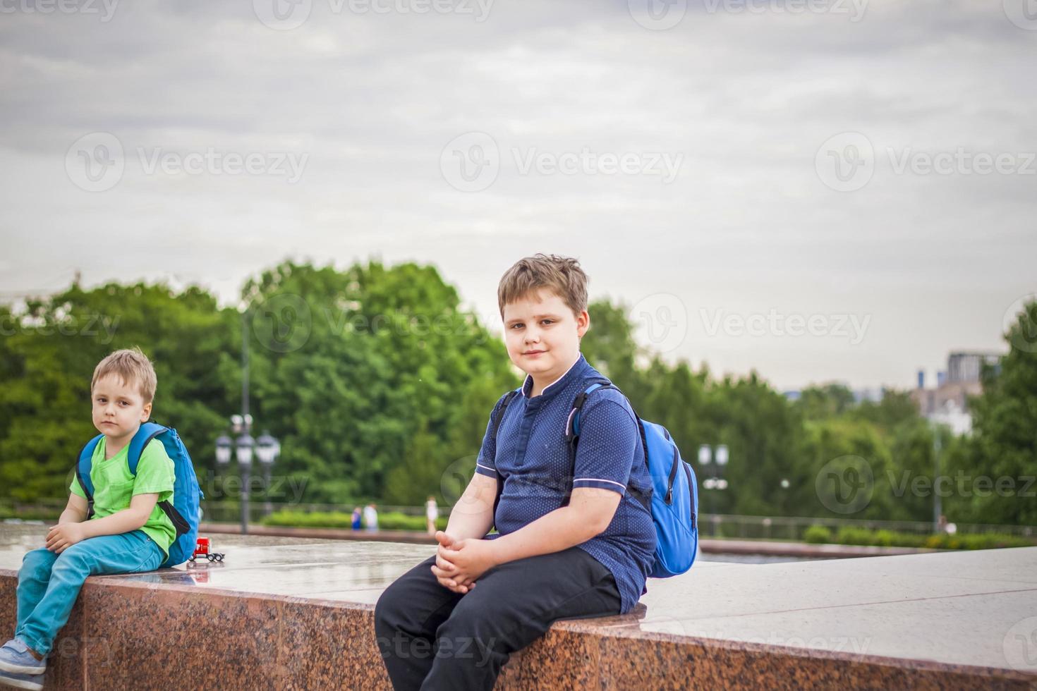 Portrait of a child, a boy against the backdrop of urban landscapes of skyscrapers and high-rise buildings in the open air. Children, Travel. Lifestyle in the city. Center, streets. photo
