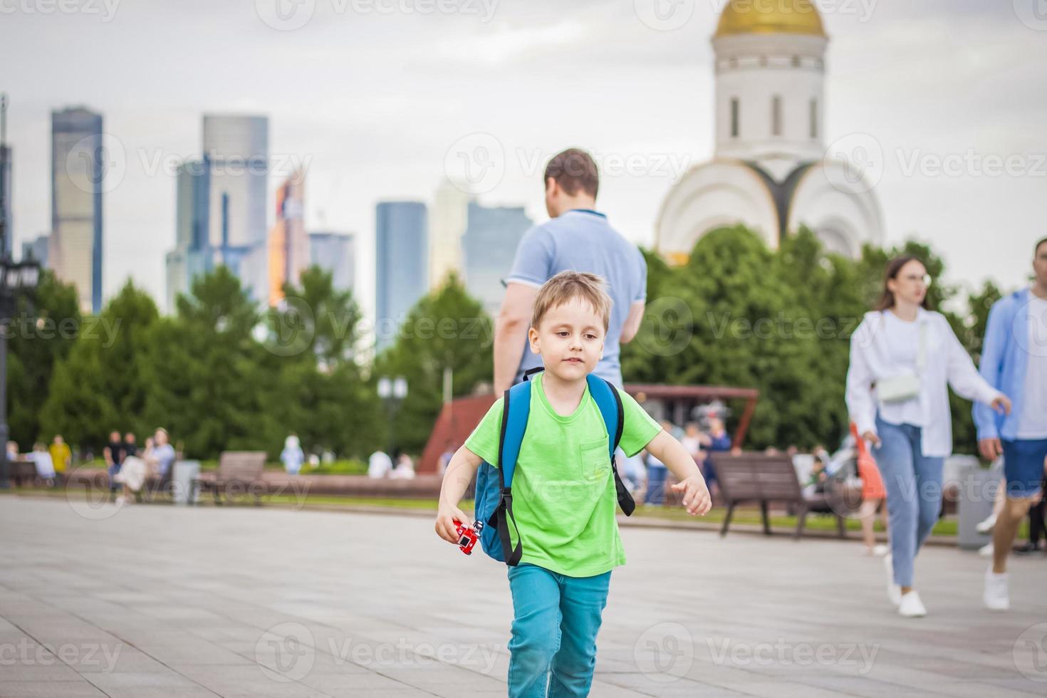 retrato de un niño, un niño en el contexto de paisajes urbanos de rascacielos y edificios de gran altura al aire libre. niños, viajes. estilo de vida en la ciudad. centro, calles. foto