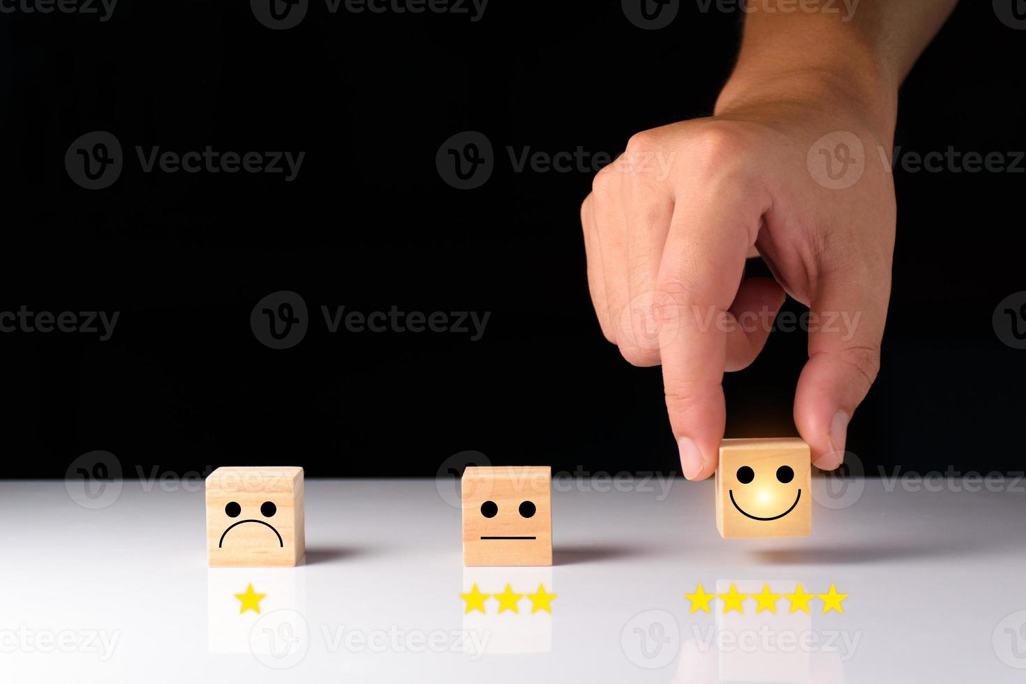 Customer service and Satisfaction feedback concept ,Business people show feedback with smile face wood cube happy Smiley face icon satisfaction in service. wood cubes rating. wood cubes ideas. photo