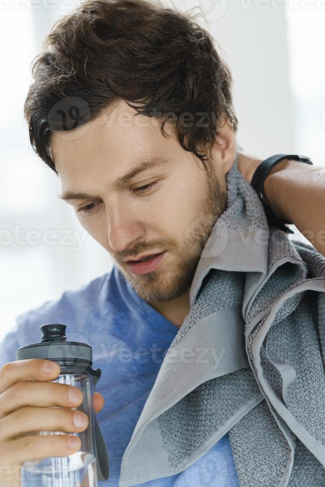 Hombre Hermoso Con La Botella De Agua Y De Toalla Que Tienen Una Rotura  Después De Entrenamiento En Gimnasio Foto de archivo - Imagen de belleza,  aptitud: 103410206