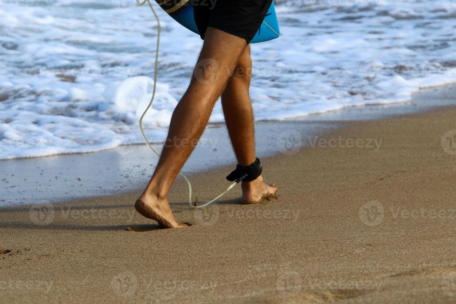 A man walks barefoot on the sand by the sea photo