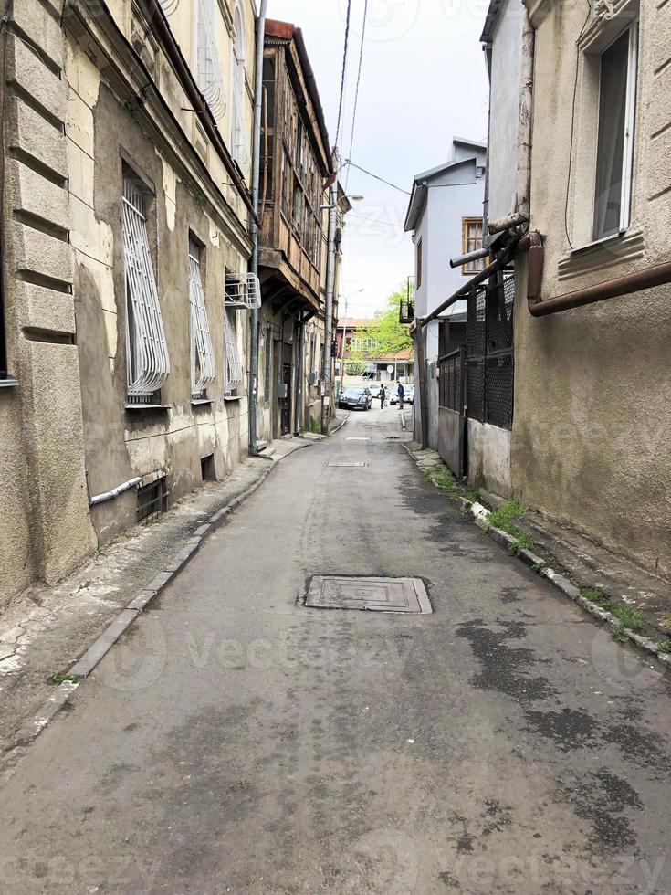 Beautiful old brown dilapidated three-story houses of the building in a pebble on a narrow street with windows and balconies, slums terraces in the old urban area of the city photo