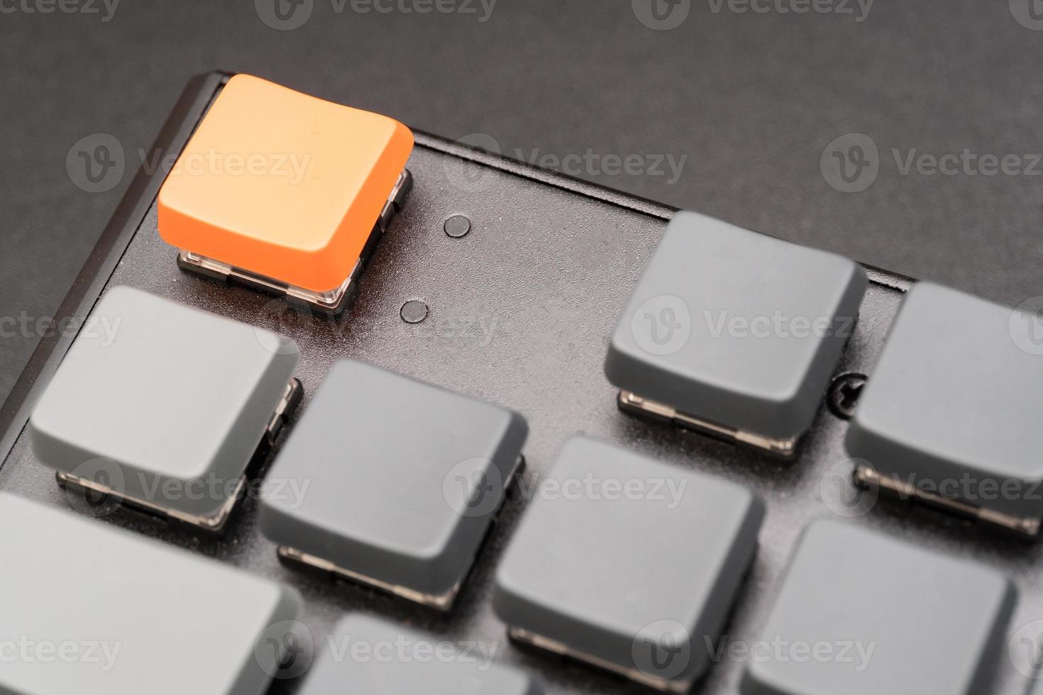 Modern keyboard with blank orange and gray key to enter text or logo with copy space. photo