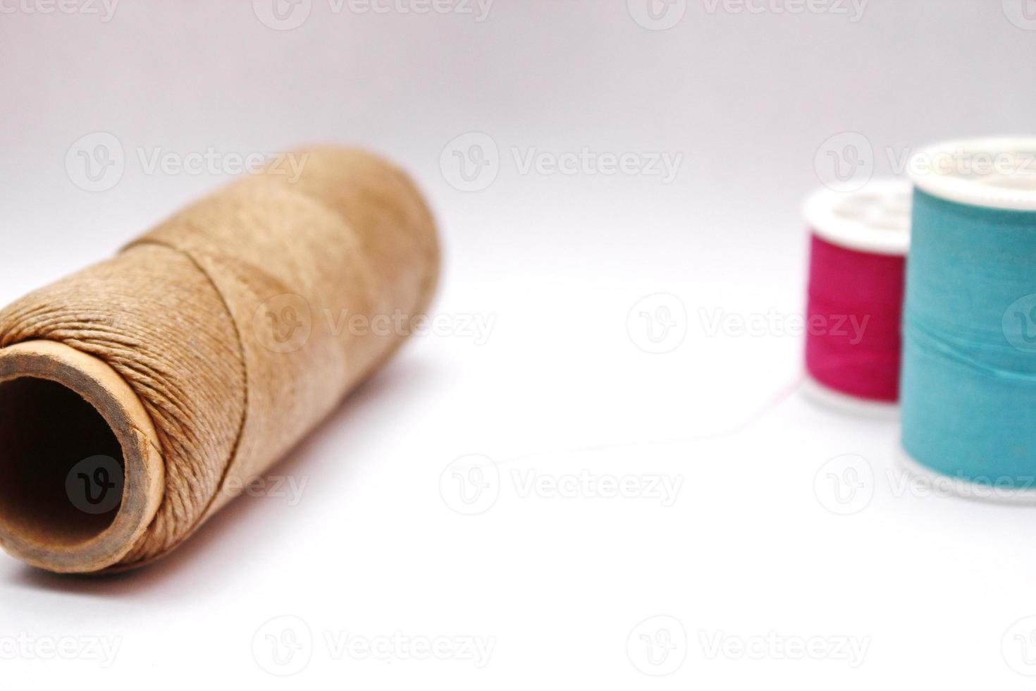 Green, red, brown spools placed on a white background. photo