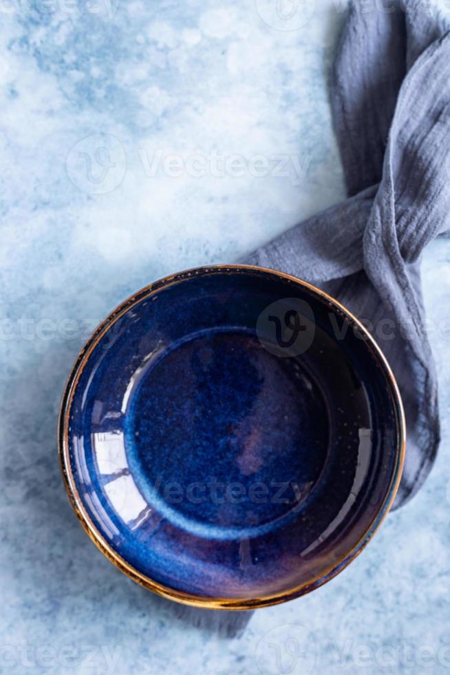 Empty craft blue marble plate and kitchen towel, blue concrete background. Food display menu template. Top view. photo