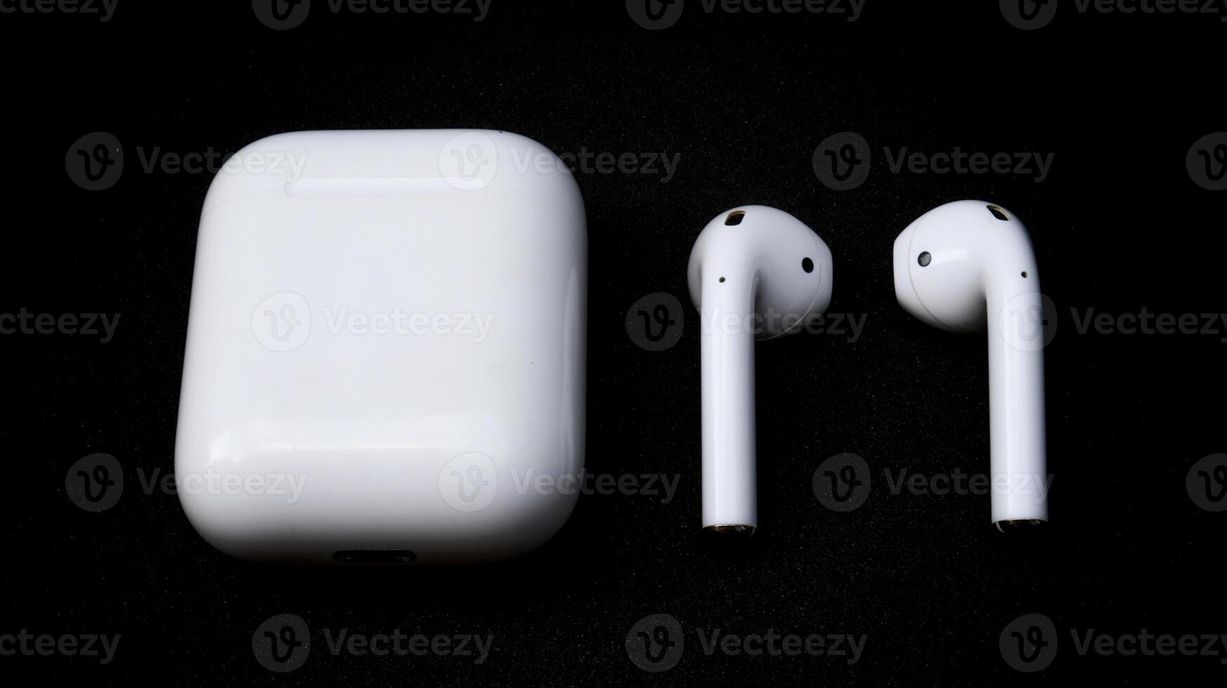 White ear pods with black isolated background, detail close up wireless earphone for daily smart phone entertainment and connectivity. photo