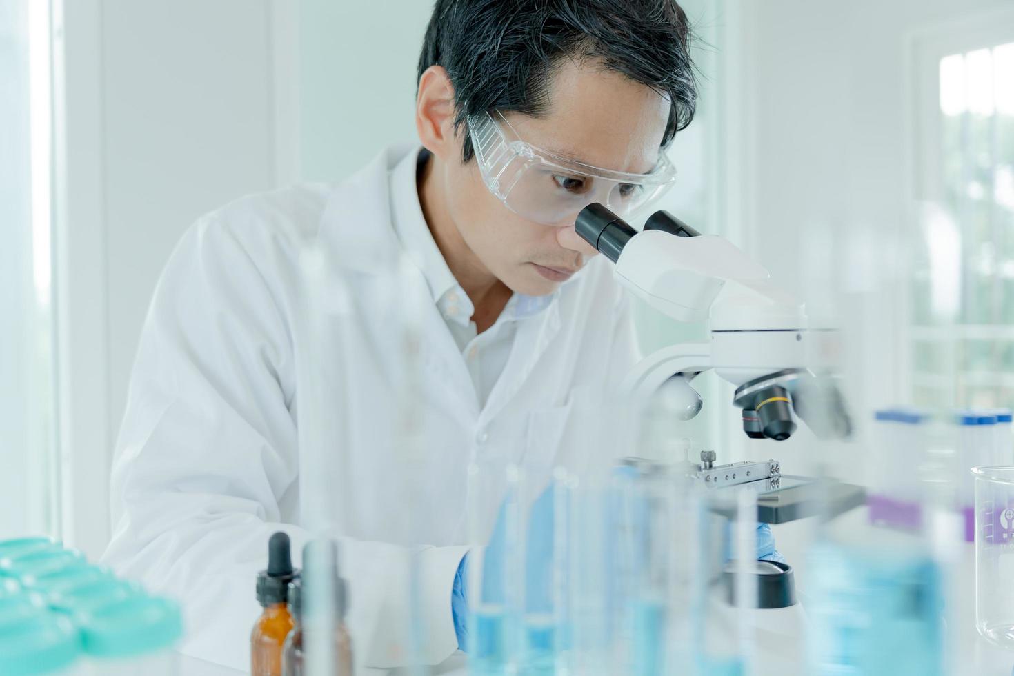 Scientist analyze biochemical samples in advanced scientific laboratory. Medical professional use microscope look microbiological developmental of viral. Biotechnology research in science lab. photo