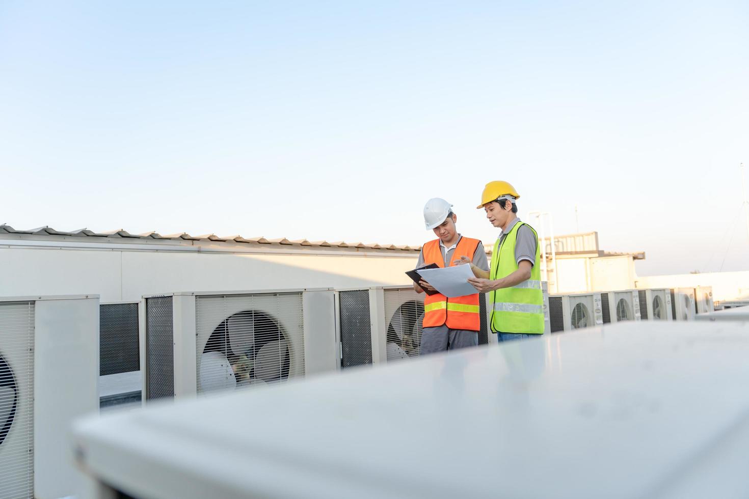 Engineers use blueprint check air condition systems on site. Contractor and inspector inspection compressor during project. maintenance team check quality assurance. Audit, inspect, quality control. photo