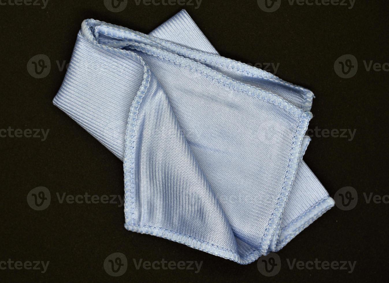 Light blue cloth for wiping.  Towel on a black background. photo