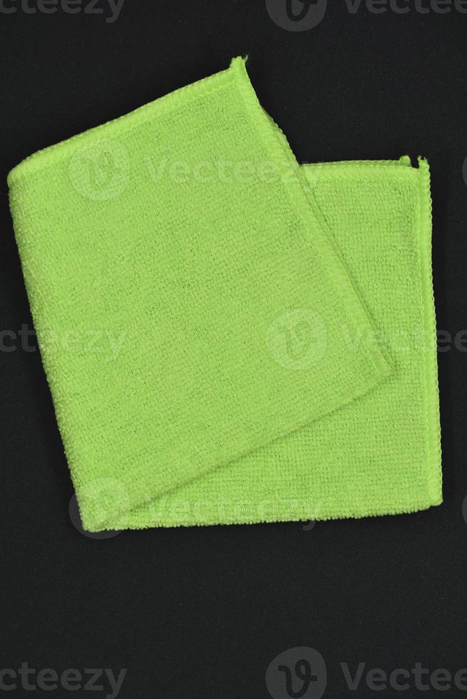 A green cloth for wiping. A terry towel. A rag for cleaning the premises. A green towel. photo