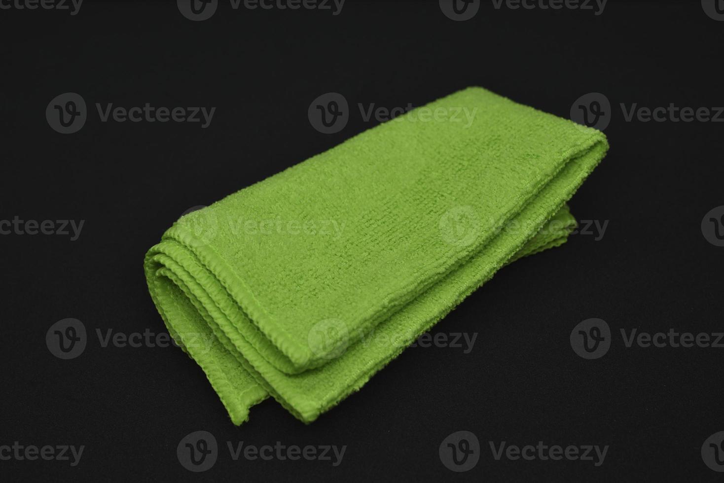 A green cloth for wiping. A terry towel. A rag for cleaning the premises. A green towel. photo
