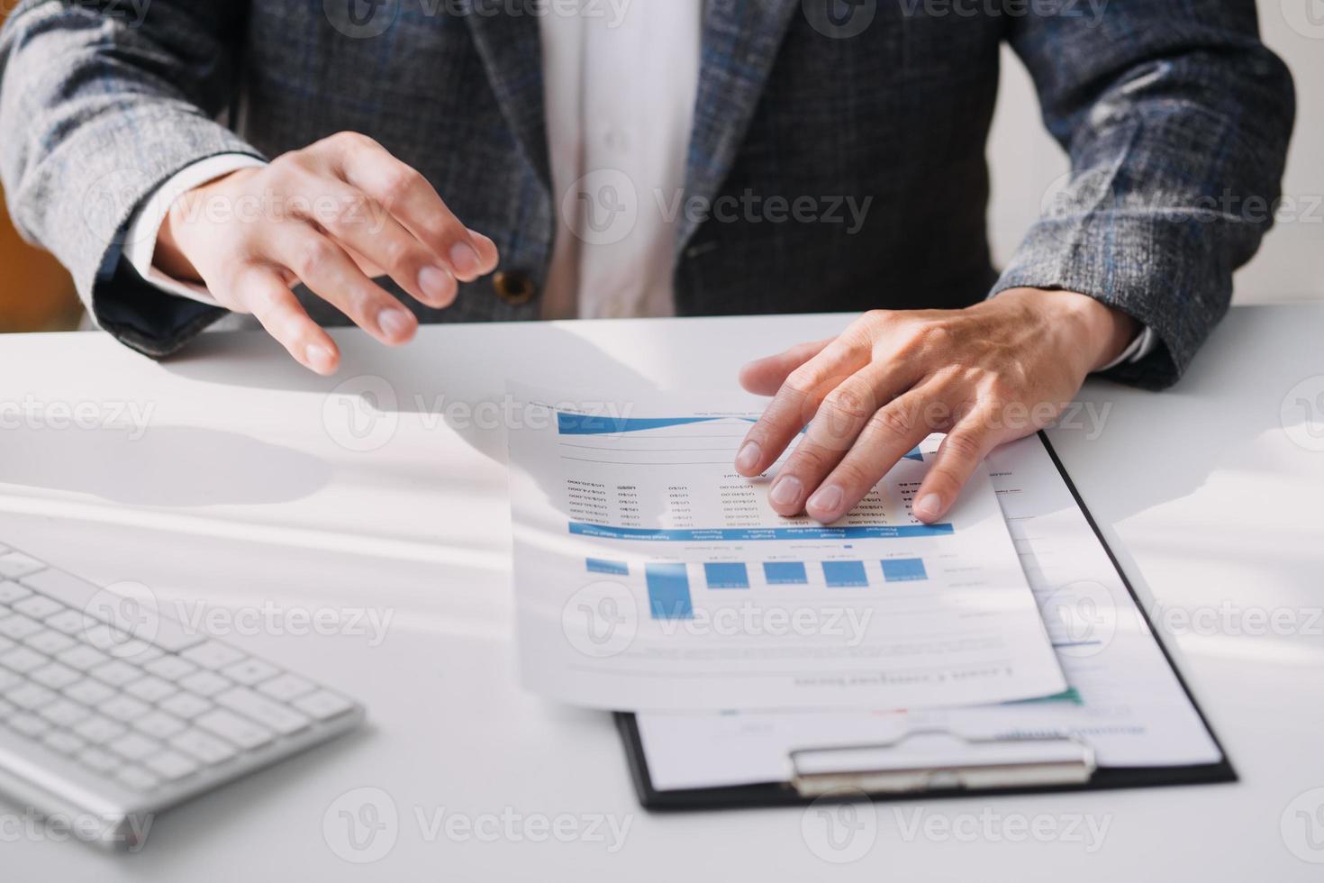 Asian Business woman using calculator and laptop for doing math finance on an office desk, tax, report, accounting, statistics, and analytical research concept photo