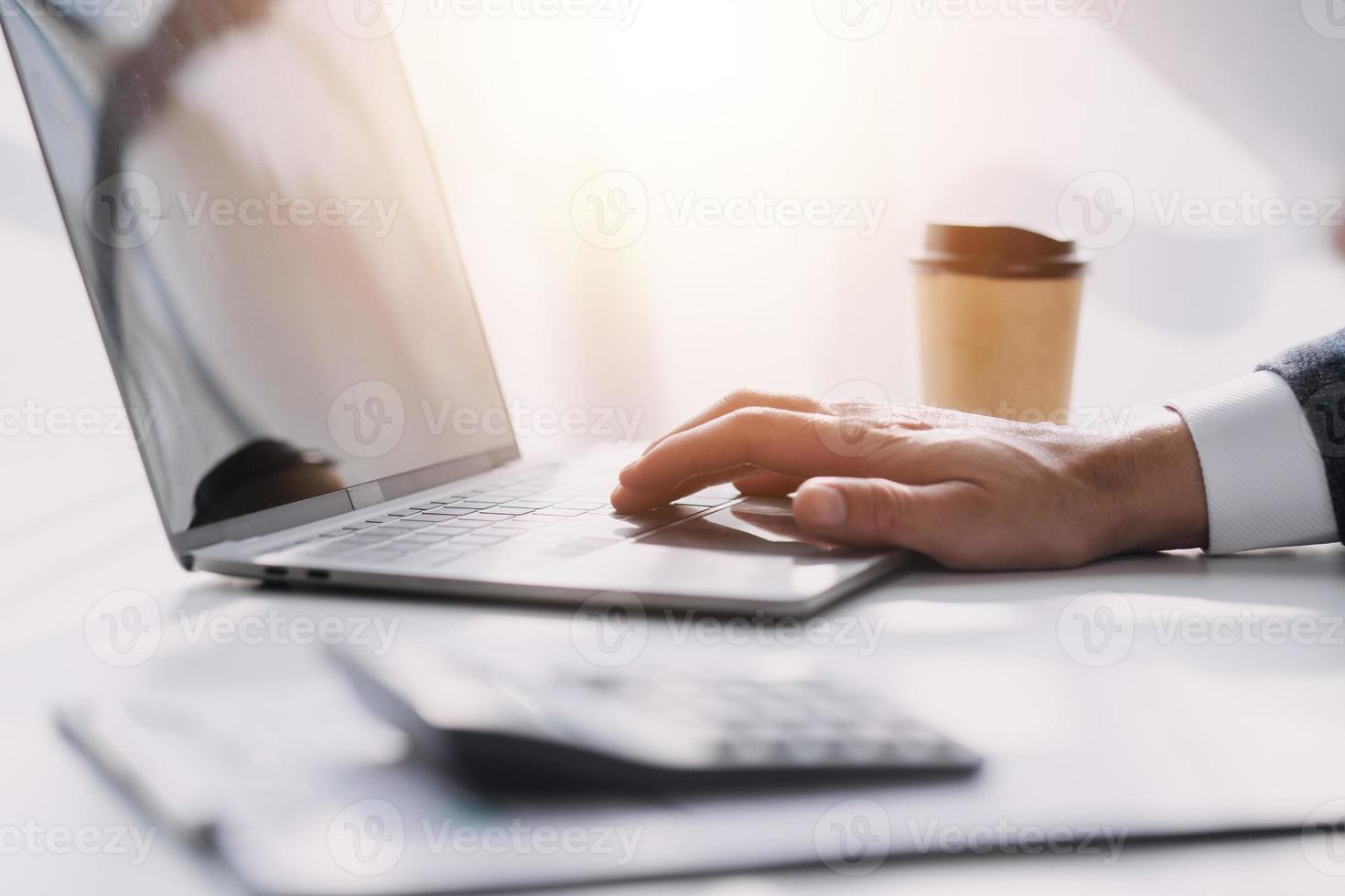 Asian Business woman using calculator and laptop for doing math finance on an office desk, tax, report, accounting, statistics, and analytical research concept photo