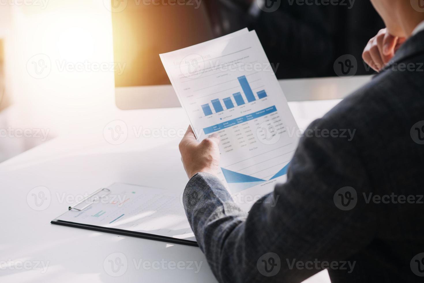 Asian Business woman using calculator and laptop for doing math finance on an office desk, tax, report, accounting, statistics, and analytical research concept photo