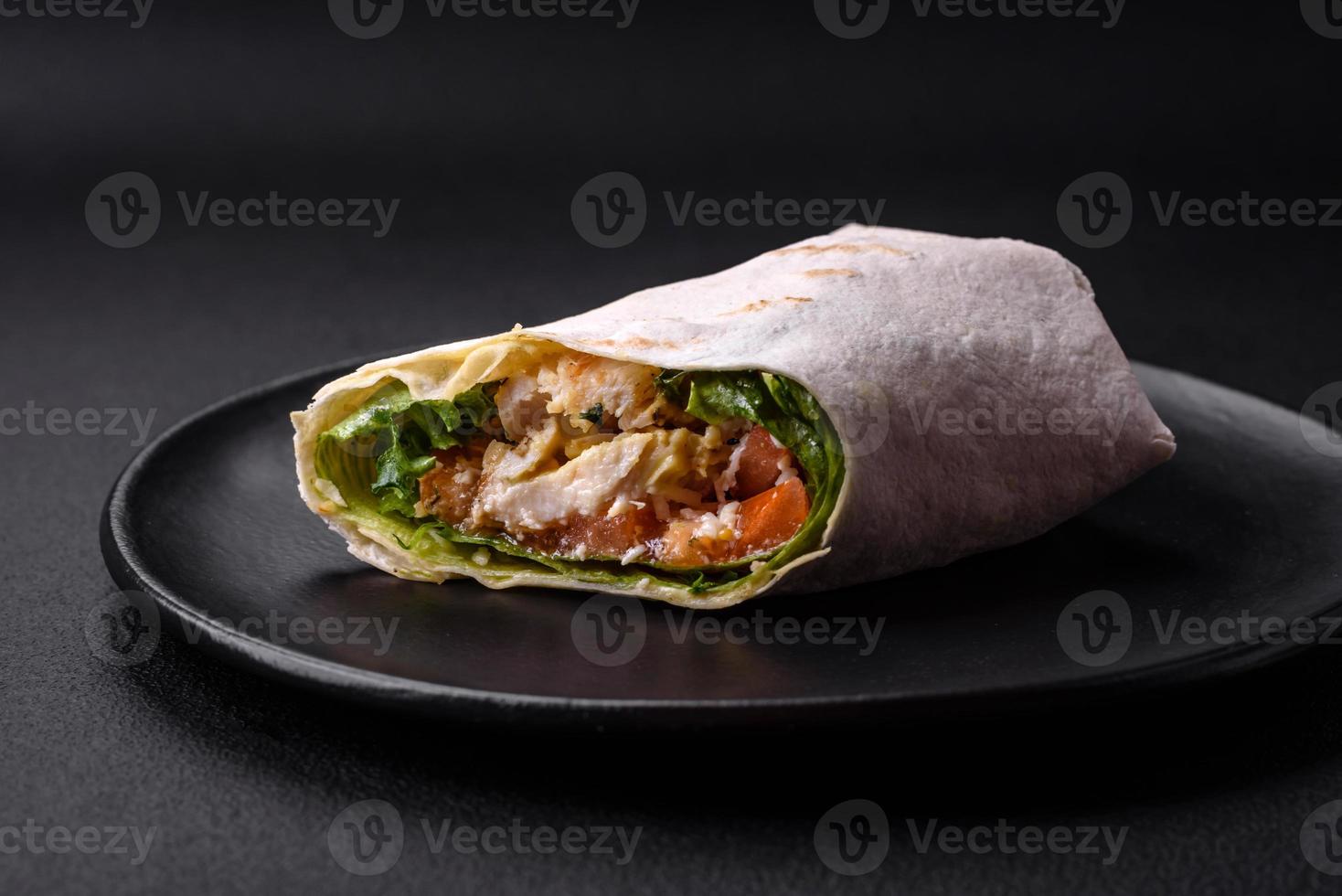 Delicious fresh roll with chicken, tomatoes, lettuce and cucumber in pita bread photo