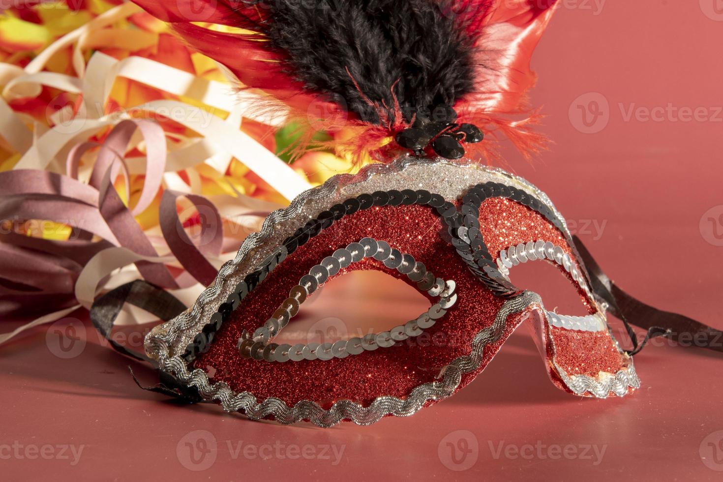 Venetian carnival mask with feathers, and typical elements in the background photo